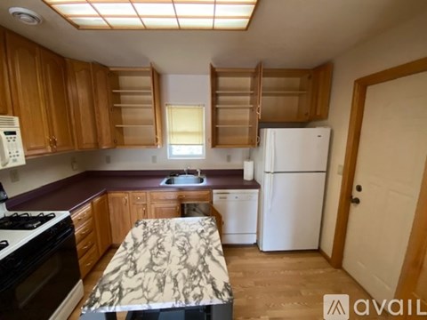 A kitchen with wooden cabinets and a marble countertop.
