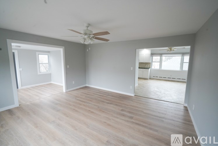 A room with a ceiling fan and light, and a window with blinds.