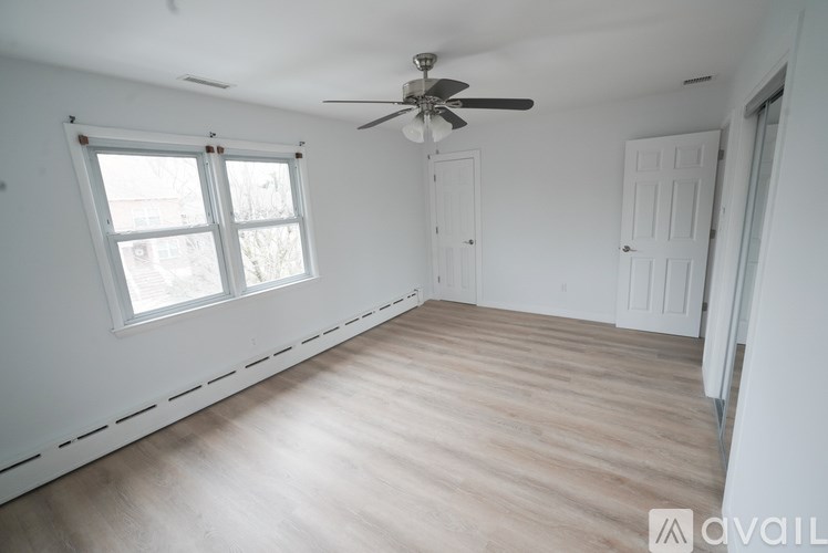 A room with a ceiling fan and a window.