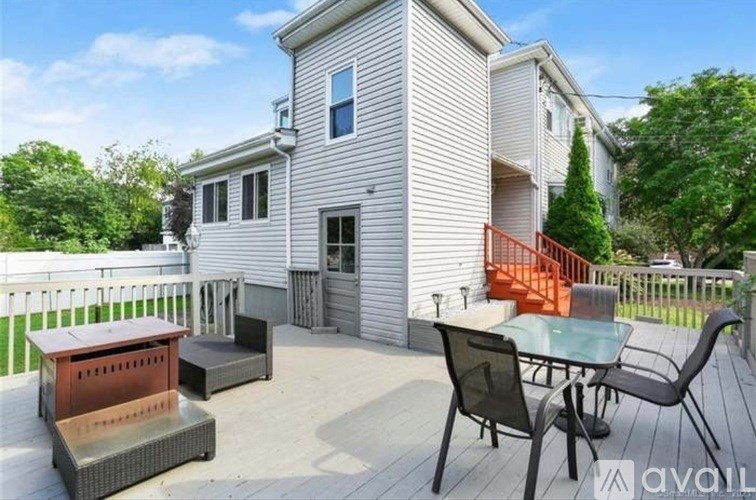 A house with a deck has a table and chairs on it.