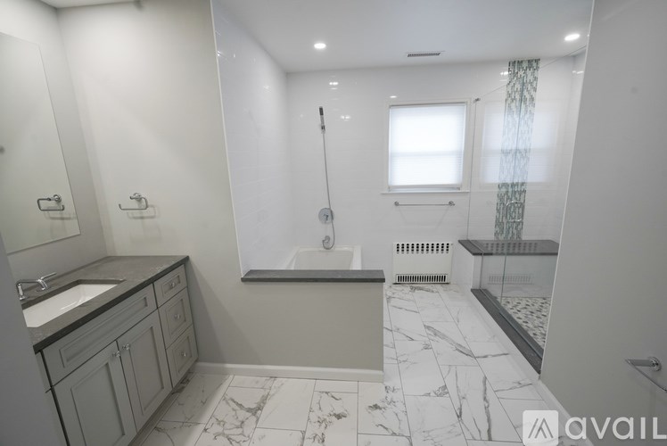 A bathroom with a marble floor and a window.