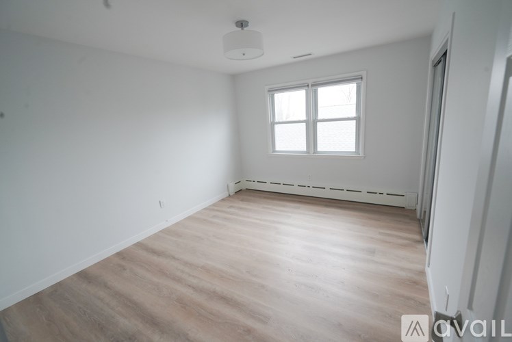 A room with wooden flooring and a window.
