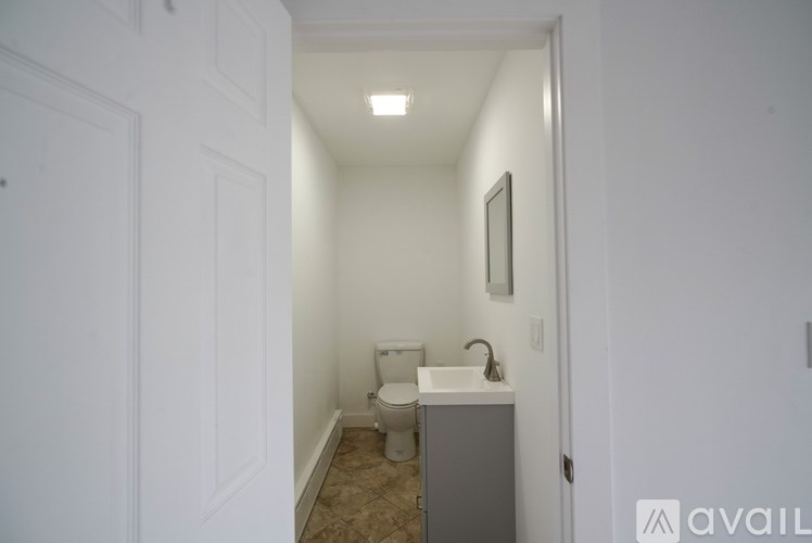 A small bathroom with a toilet, sink, and cabinet.