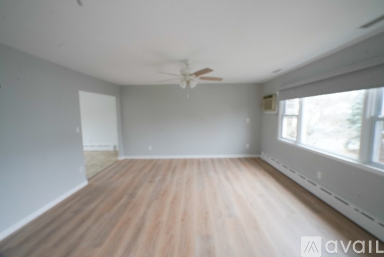 A room with wooden flooring and a ceiling fan.
