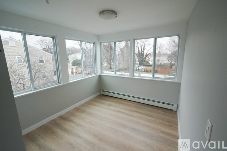 A room with a window overlooking a residential area.