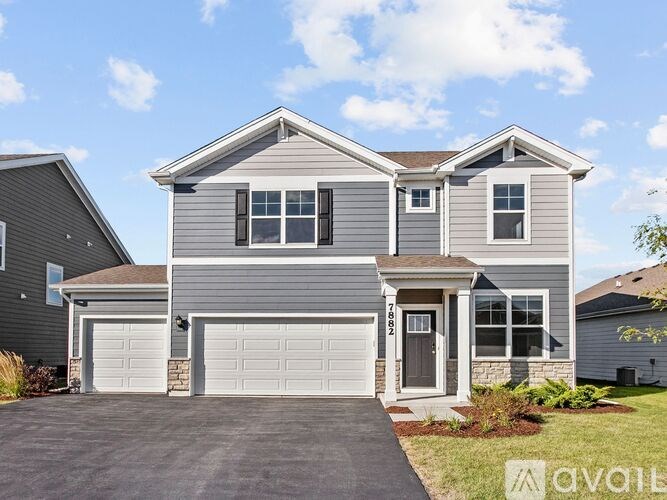 A two-story house with a garage is for sale.