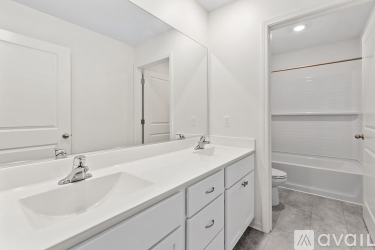A bathroom with a white sink and a white toilet.