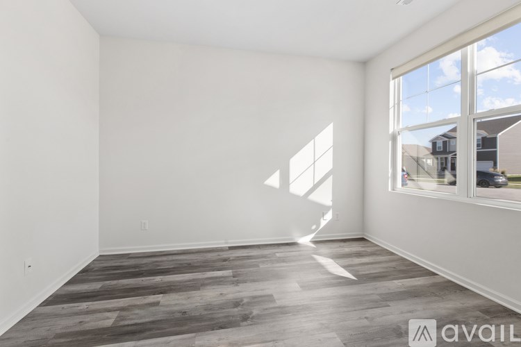 A room with wooden flooring and a large window.