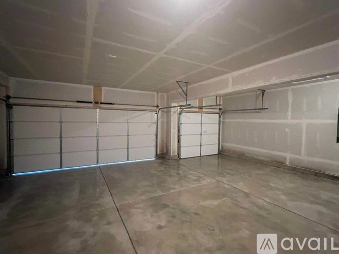 A spacious garage with a concrete floor and white walls.