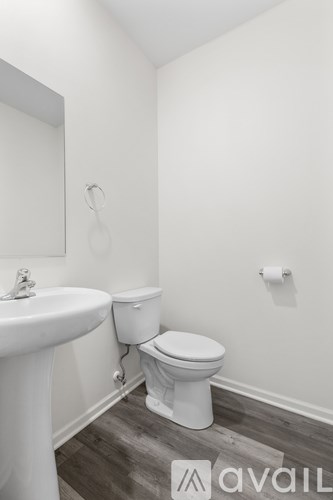 A white toilet sits next to a sink in a small bathroom.