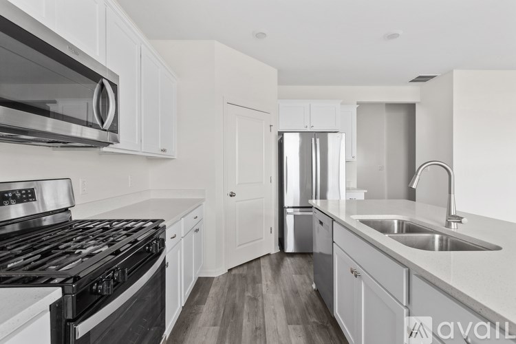 A modern kitchen with white cabinets and a black stove top oven.