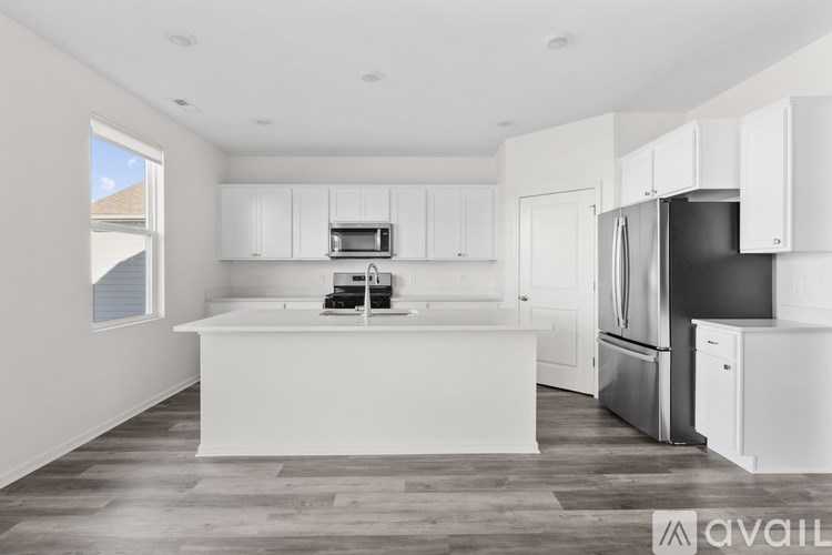 A modern kitchen with white cabinets and appliances.