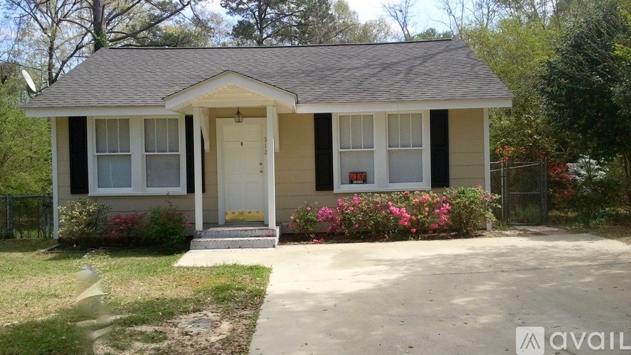 A small house with a front porch and a white door.