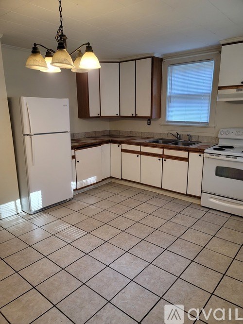A kitchen with white appliances and brown cabinets.