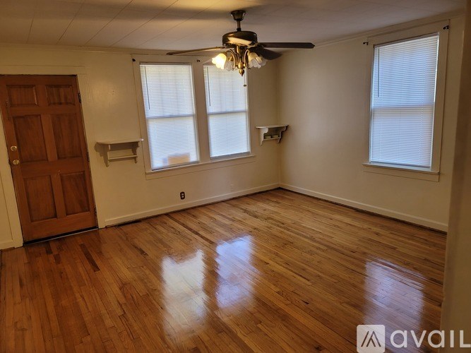 A room with wooden floors and a ceiling fan.