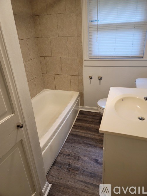 A bathroom with a tub, sink and toilet.