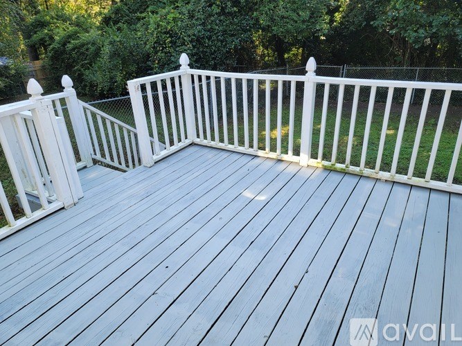 A deck with white railings and a white fence.
