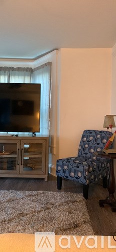 A living room with a television, a chair, and a cabinet.