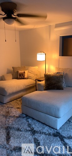 A living room with a white couch and a ceiling fan.