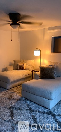 A living room with a white couch and a ceiling fan.