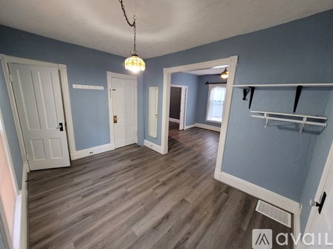 A room with a wooden floor and a hanging light fixture.