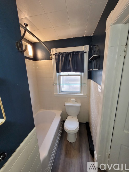 A bathroom with a white toilet and a white bathtub.