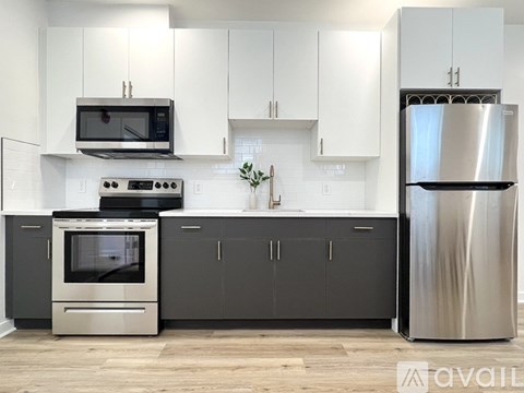 A modern kitchen with a stainless steel refrigerator, oven, and microwave.