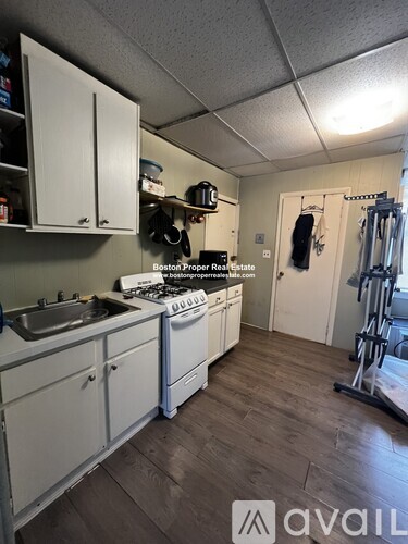 A kitchen with white cabinets and a stove top oven.