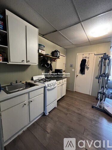 A kitchen with white cabinets and a stove top oven.