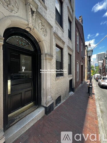 A building with a black door and a window with a stained glass design.