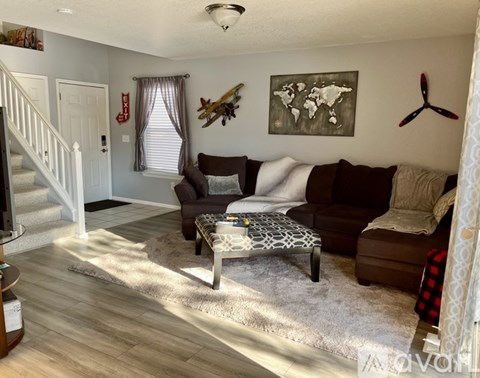 A living room with a brown couch and a coffee table.