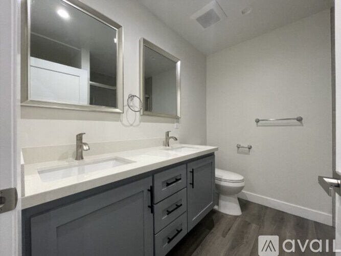 A bathroom with a toilet, sink, and mirror.