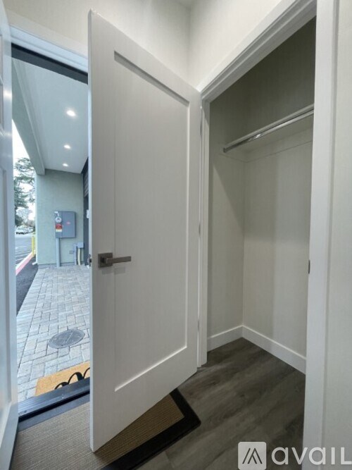 A white door is open to a small, empty closet.