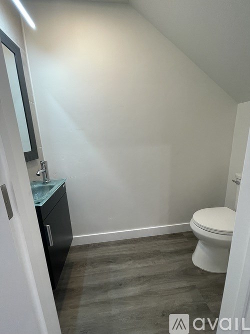 A bathroom with a toilet, sink, and mirror.