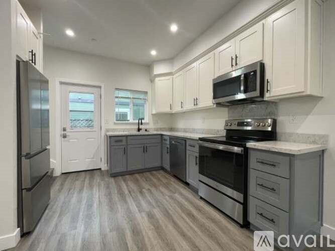 A kitchen with a refrigerator, oven, and microwave.