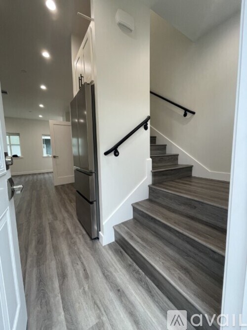 A staircase with wooden steps and a black handrail.