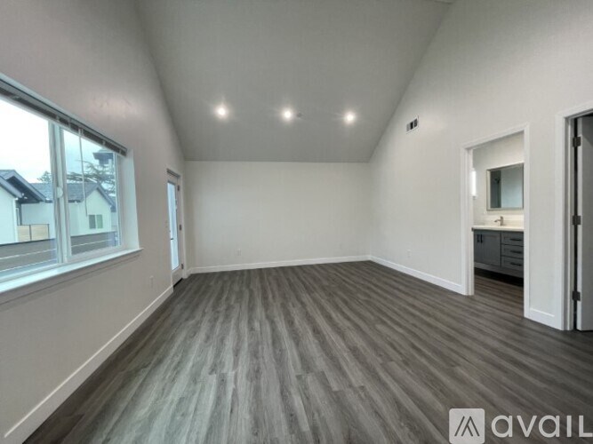 A spacious room with grey flooring and white walls.