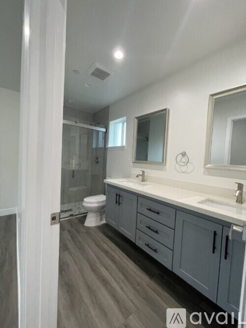 A bathroom with a toilet, sink, and mirror.