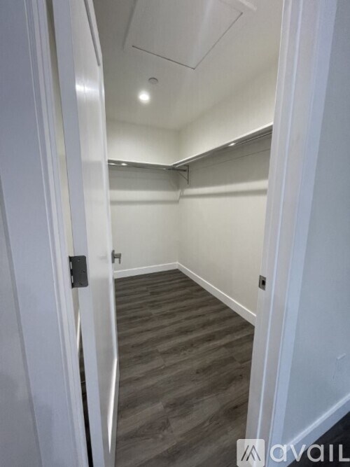 A hallway with a white door and grey flooring.