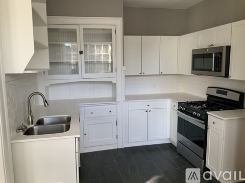A kitchen with white cabinets and a black stove top oven.