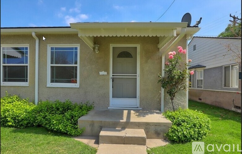 A house with a red door and a green roof is for sale.