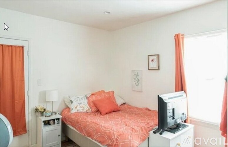 A bedroom with a bed, nightstand, and television.