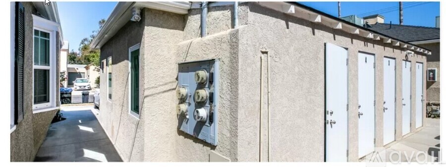 A row of white doors are on the side of a building.