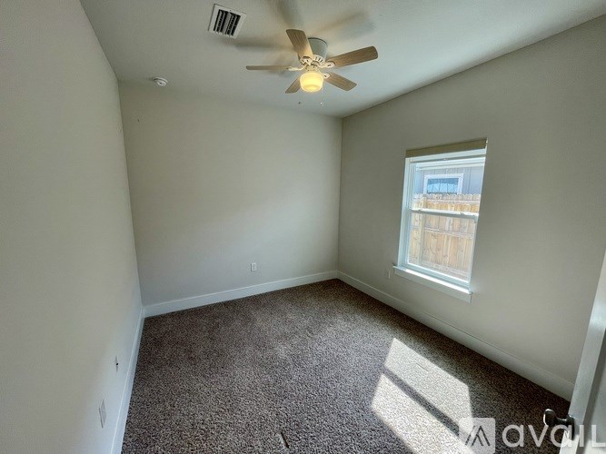 A room with a ceiling fan and a window.