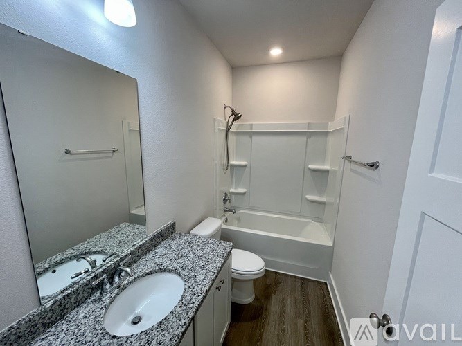 A bathroom with a toilet, sink, and bathtub.