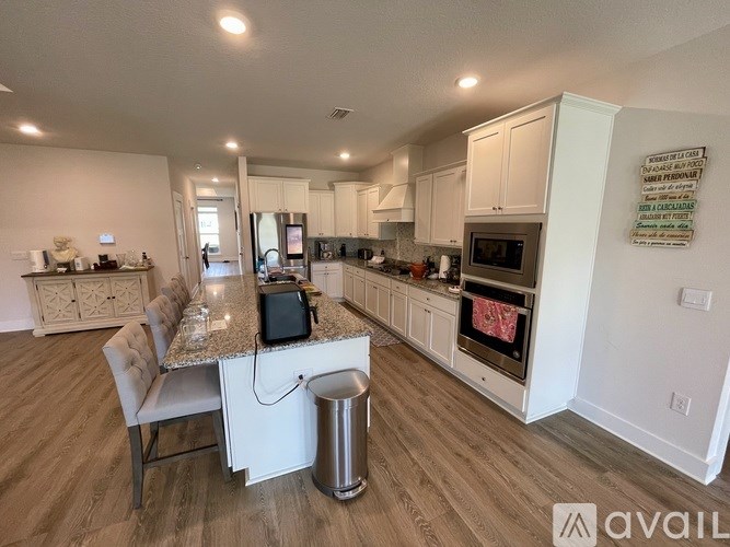 A kitchen with a white island and a microwave oven.