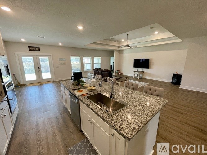 A modern kitchen with granite countertops and a central island.