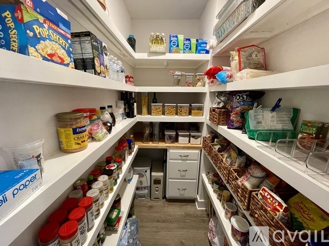 A pantry with white shelves and a variety of food items.