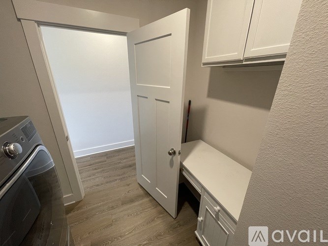 A small kitchen with a washing machine and a white door.