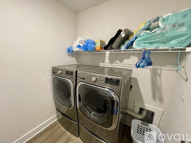 A laundry room with two washing machines and a clothes dryer.